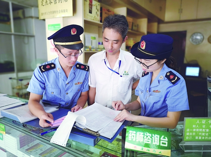 執(zhí)法人員在一家藥店檢查特殊藥品進(jìn)貨臺賬。