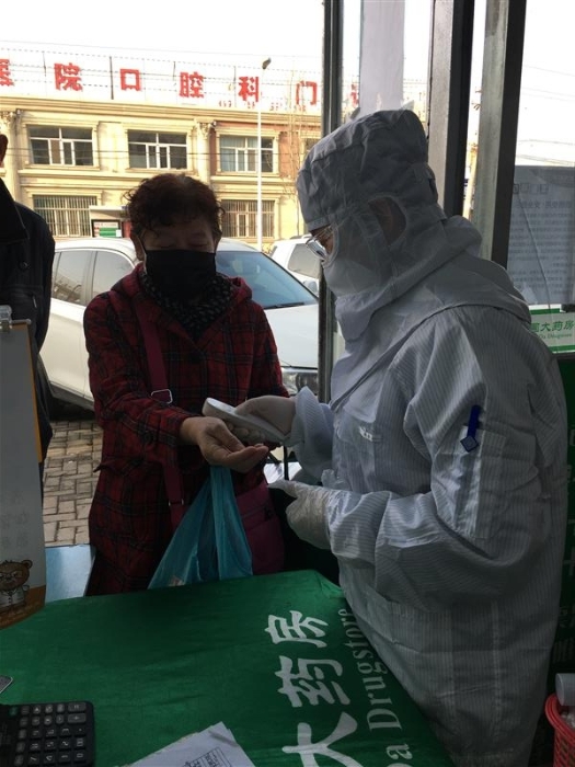 趙海霞為進(jìn)店顧客測量體溫。