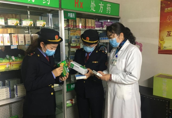 監(jiān)管人員正在藥品經(jīng)營企業(yè)檢查該企業(yè)藥品儲存情況