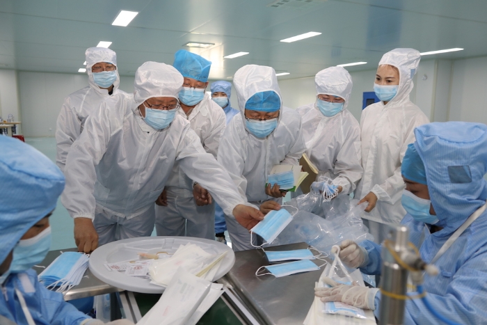 “五_一”小長假期間，新疆維吾爾自治區(qū)藥監(jiān)局黨組書記、局長張鈺祥（左一）帶隊(duì)赴哈密市調(diào)研口罩生產(chǎn)企業(yè)。（馬少賓 攝）