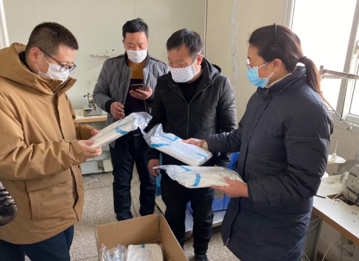 監(jiān)管人員對防護(hù)服生產(chǎn)企業(yè)進(jìn)行檢查。