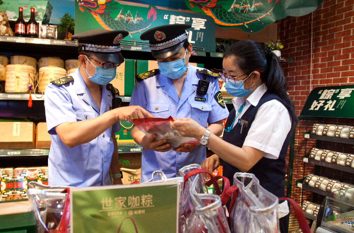 東城區(qū)市場監(jiān)管局執(zhí)法人員在超市檢查粽子保質(zhì)期。