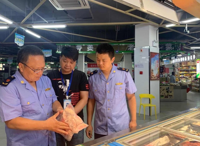 圖為該局執(zhí)法人員在一家農(nóng)貿(mào)市場(chǎng)冷凍食品專柜進(jìn)行檢查。