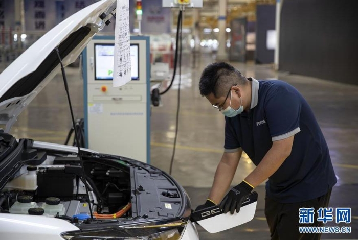 一名工作人員在北汽昆明基地檢查新能源汽車充電口（8月18日攝）。新華社記者 孫敏 攝