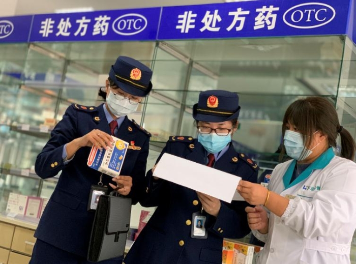 圖為該局執(zhí)法人員對發(fā)燒類藥品銷售登記進行檢查。