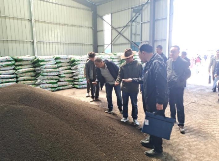 在青海省果洛藏族自治州甘德縣江千鄉(xiāng)的有機(jī)肥倉庫，江千鄉(xiāng)黨委書記塔松（中間戴帽者）正在檢查有機(jī)肥質(zhì)量。（2020年7月22日攝）。