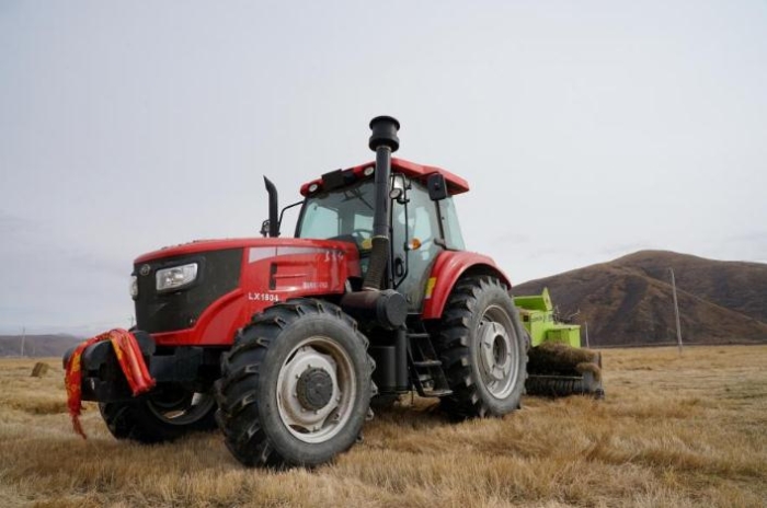 在青海省果洛藏族自治州甘德縣江千鄉(xiāng)，一位牧民正在飼草基地駕駛打捆機(jī)工作。（2020年11月3日攝）。新華社記者陳凱 攝