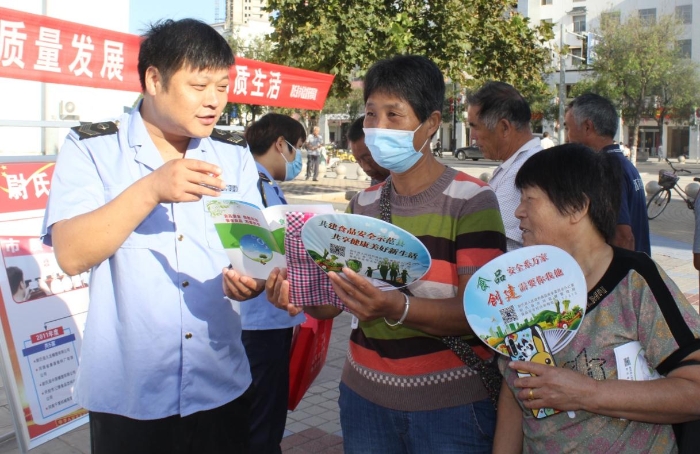 圖為執(zhí)法人員向群眾宣講食品安全知識。