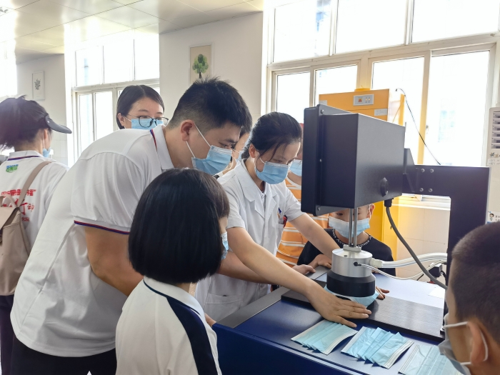 圖為技術(shù)人員在講解口罩的檢驗方法和原理。（喻燦華 攝）