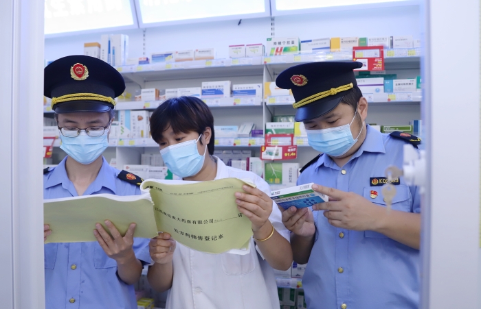 圖為9月13日?qǐng)?zhí)法人員在一家藥店查看網(wǎng)絡(luò)藥品銷售登記情況，并核對(duì)處方藥處方單。