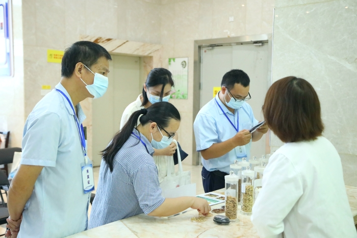 圖為工作人員向市民代表講解中藥材（枸杞、菊花等）真?zhèn)舞b別知識。