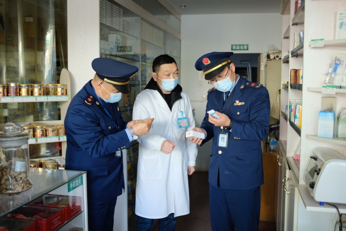 圖為執(zhí)法人員在一家藥店檢查其經(jīng)銷的藥品外包裝上標(biāo)簽是否規(guī)范，并核對相關(guān)購銷登記臺賬的信息是否合規(guī)。