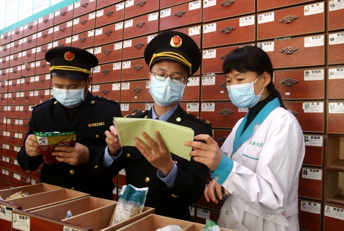 圖為11月24日執(zhí)法人員對一家藥店檢查中藥飲片。
