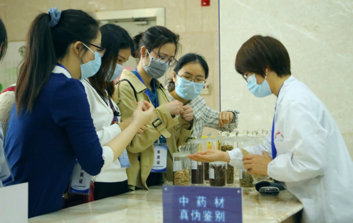 圖為工作人員為市民代表講解中藥材鑒別知識(shí)。