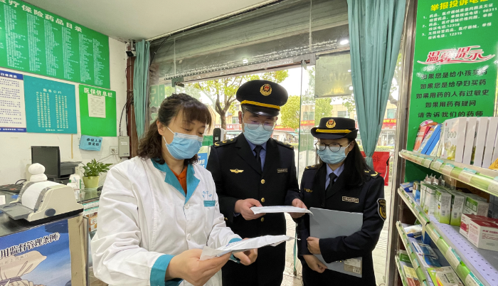 圖為執(zhí)法人員在一家藥店檢查疫情防控情況。
