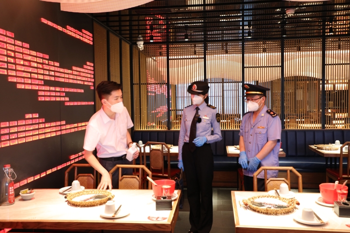 圖為海淀區(qū)市場監(jiān)管局執(zhí)法人員在現(xiàn)場檢查疫情防控及食品安全情況。