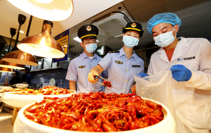 圖為8月2日，淮北市市場監(jiān)督管理部門工作人員在夜市餐飲街區(qū)現(xiàn)場取樣。