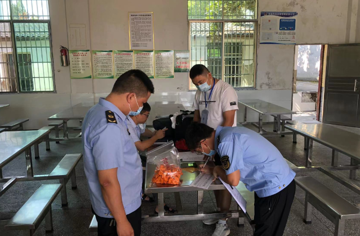 圖為該局執(zhí)法人員在一家學(xué)校食堂檢查食品儲(chǔ)存情況。