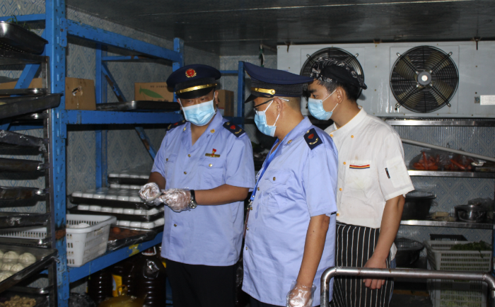 圖為該局執(zhí)法人員在一學(xué)校食堂檢查食品安全制度落實(shí)情況。