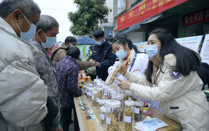 圖為工作人員現(xiàn)場向群眾講解常用中藥材的鑒別知識，普及藥品安全相關(guān)法律法規(guī)。