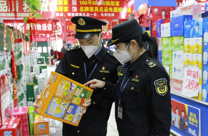 圖為該局執(zhí)法人員在一家商場檢查在售食品是否超過保質(zhì)期。