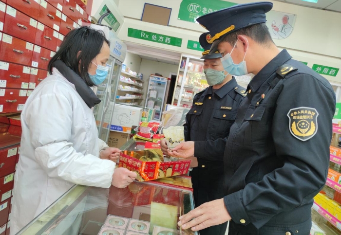 圖為執(zhí)法人員在一家零售藥店檢查中藥飲片是否霉爛變質(zhì)。
