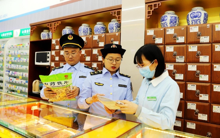 圖為4月25日，執(zhí)法人員在對(duì)一家零售藥店的中藥飲片進(jìn)行檢查。
