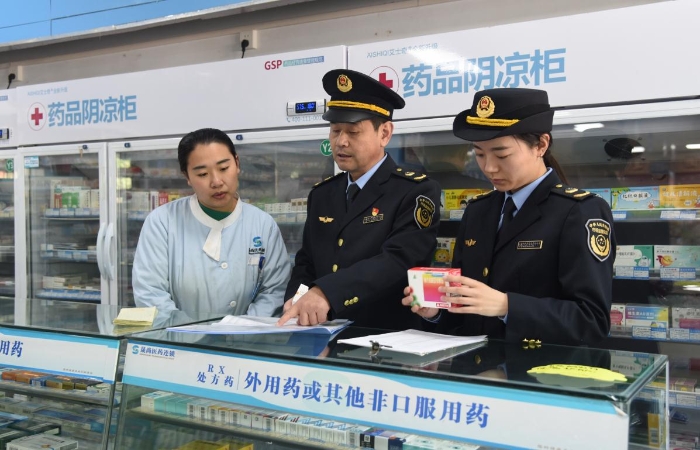 圖為執(zhí)法人員在一家藥品經(jīng)營企業(yè)檢查藥品采購和陰涼藥品儲存記錄情況。