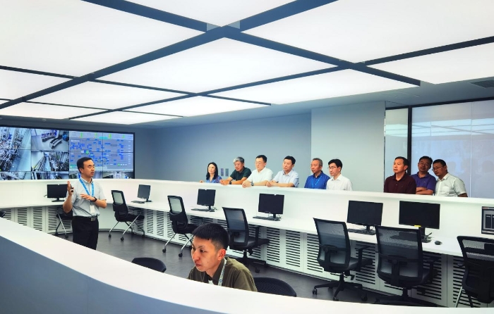 圖為各地藥品監(jiān)管部門相關(guān)人員和專家參觀調(diào)研信達生物生產(chǎn)大樓。（高銘華 攝）