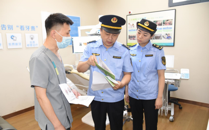 圖為該局執(zhí)法人員在一家口腔診所檢查其藥械采購索證索票情況。