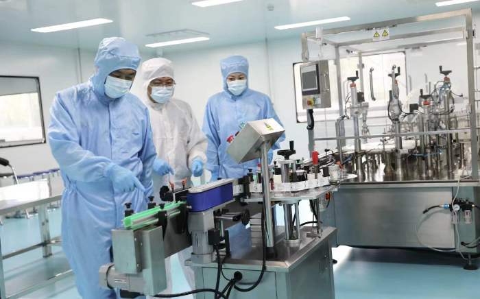 圖為執(zhí)法人員在一家醫(yī)療器械生產(chǎn)企業(yè)查看生產(chǎn)線情況。