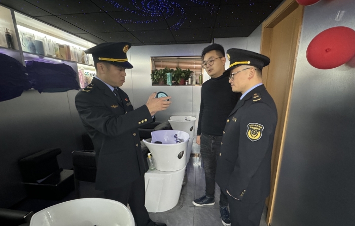 圖為執(zhí)法人員正在一家美容美發(fā)機構(gòu)進(jìn)行現(xiàn)場檢查。