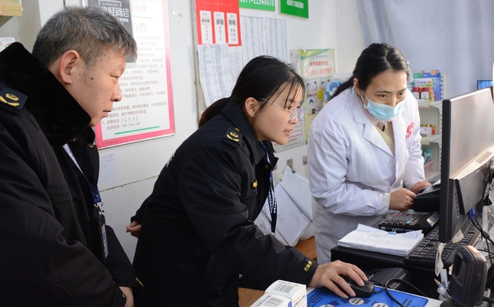 圖為執(zhí)法人員正在檢查藥品網(wǎng)絡(luò)銷售情況。