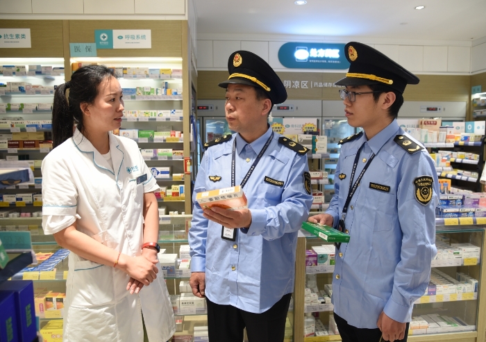 圖為執(zhí)法人員在一家藥店檢查藥品經(jīng)營情況。