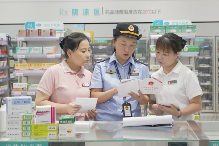 圖為8月28日，該局執(zhí)法人員向藥店經(jīng)營者解讀《藥品管理法》。（劉曉紅 董黎攝）.jpg