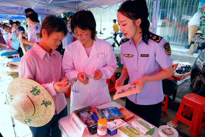 工作人員為群眾講解如何識別假冒偽劣藥品。（何正君攝）