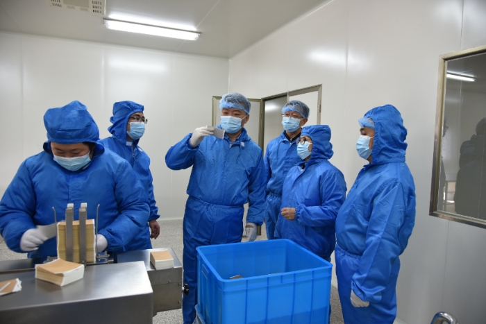 圖為甘肅省藥監(jiān)局黨組書記、局長吉永鋒（右四）帶領(lǐng)調(diào)研組在白銀振亞衛(wèi)生材料有限公司查看祖師麻關(guān)節(jié)止痛膏生產(chǎn)情況 。 （盧昌貴 攝）