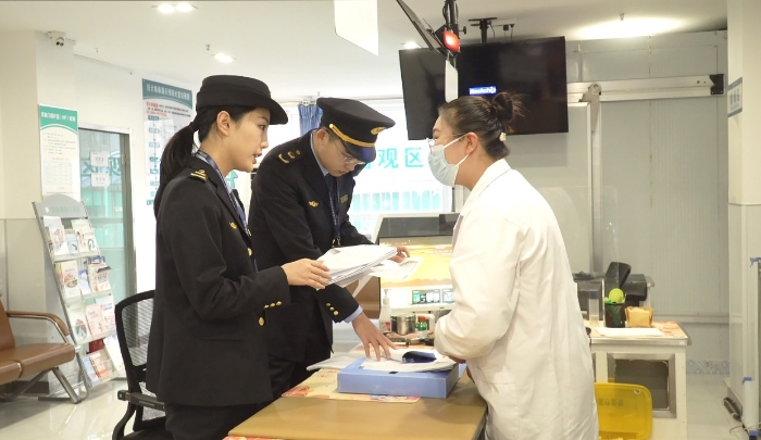 圖為該局執(zhí)法人員檢查安禾綜合門診部疫苗采購、運輸和儲存記錄單。