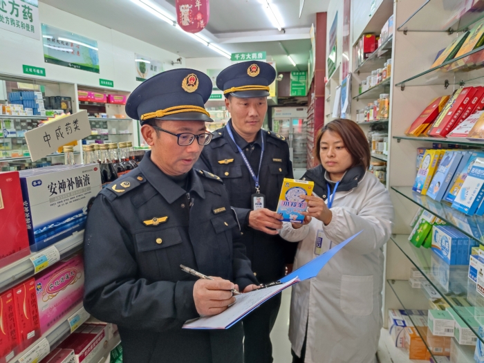 圖為近日，該局執(zhí)法人員在一家零售藥店檢查退熱貼標簽標識。（鄢國卿 攝）