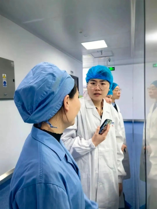 1月24日，中國醫(yī)藥報記者蔣紅瑜（右一）在桂林南藥生產(chǎn)車間采訪抗瘧藥品生產(chǎn)線改造情況