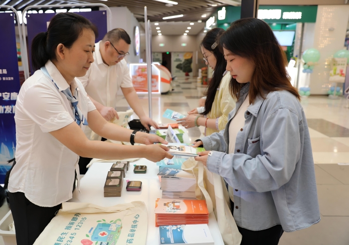 圖為工作人員向市民發(fā)放《藥品管理法實(shí)施條例》解讀以及用藥安全科普知識(shí)宣傳手冊(cè)。（葉陽(yáng)歡攝）